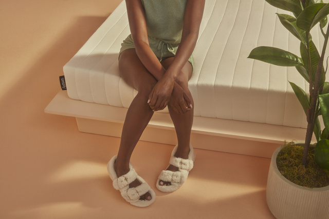 Person sitting on corner of mattress